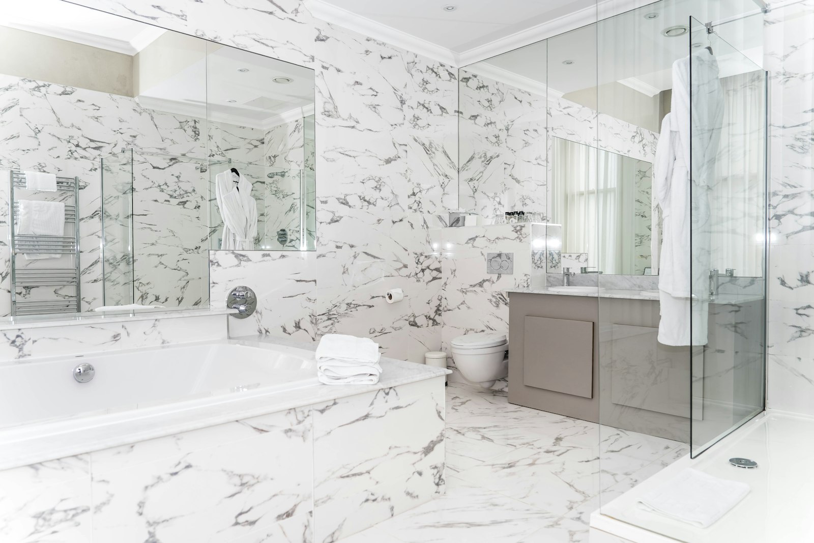 Marble-clad ensuite bathroom with freestanding bath