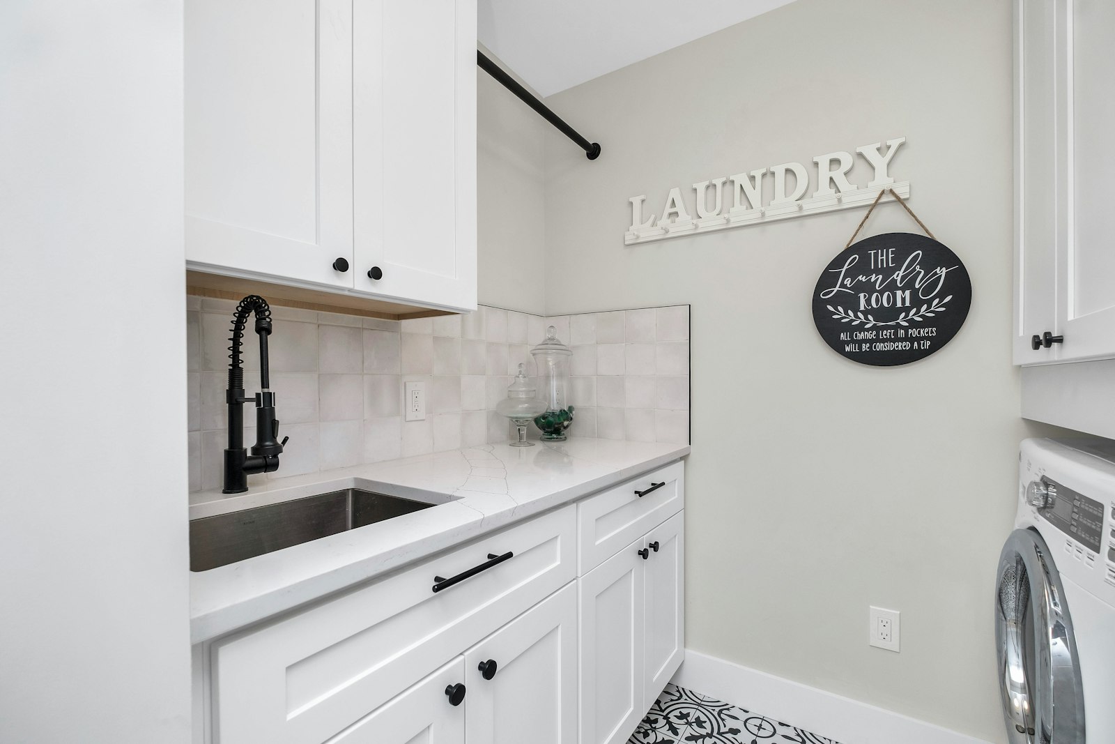 Styled laundry with white cabinetry and smart storage